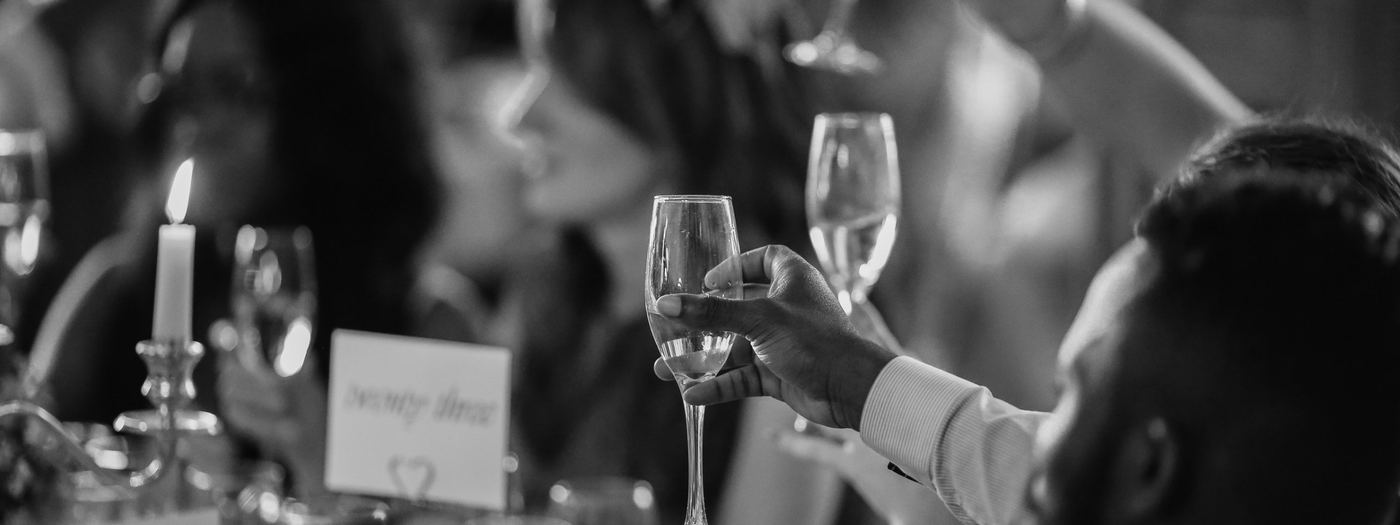 A guest raising a glass at a wedding reception