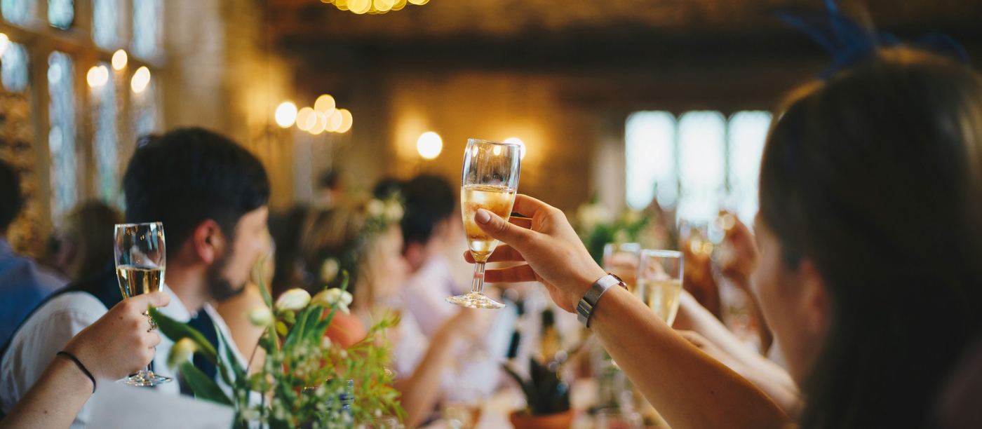 Wedding guests raising their glasses during a toast